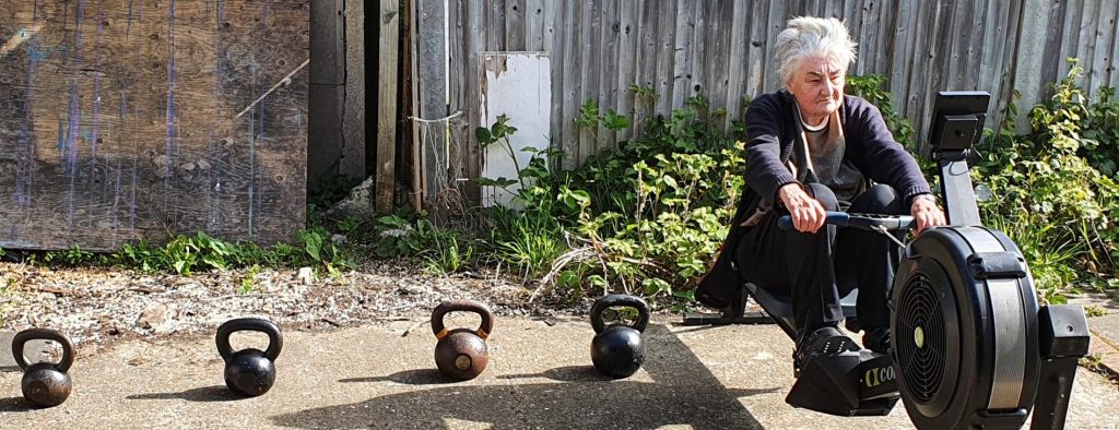 Yvonne rowing with Kettlebells on the floor next to her